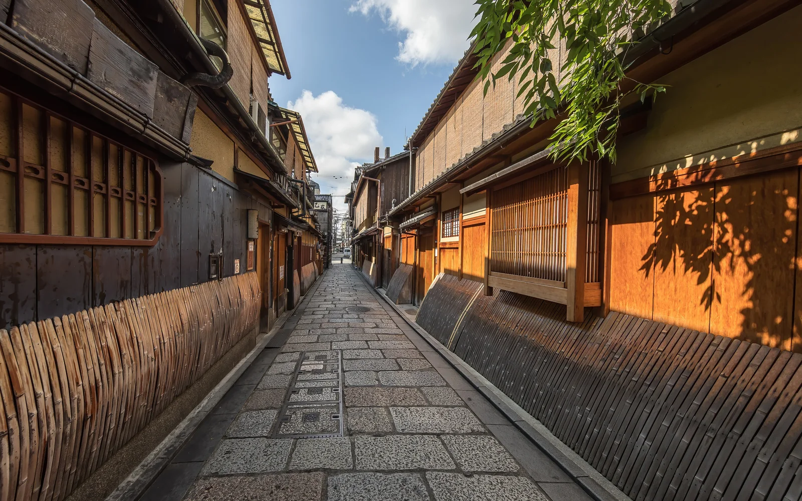 Wooden and bamboo facades lining a cobbled pedestrian lane in Gion, Kyoto